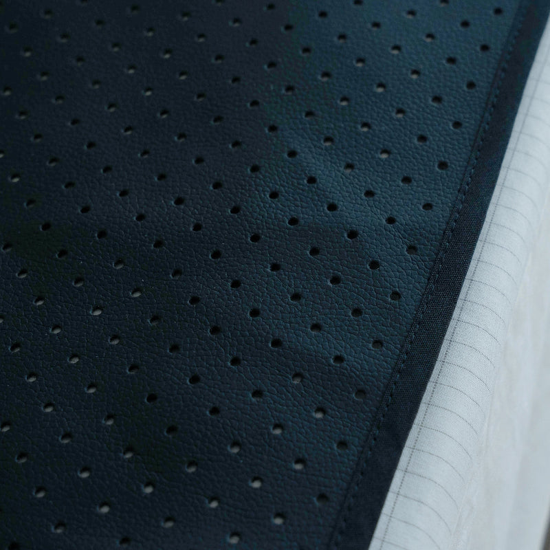 Close-up of the PU leather grounding sheet black perforated fabric on top of a bed