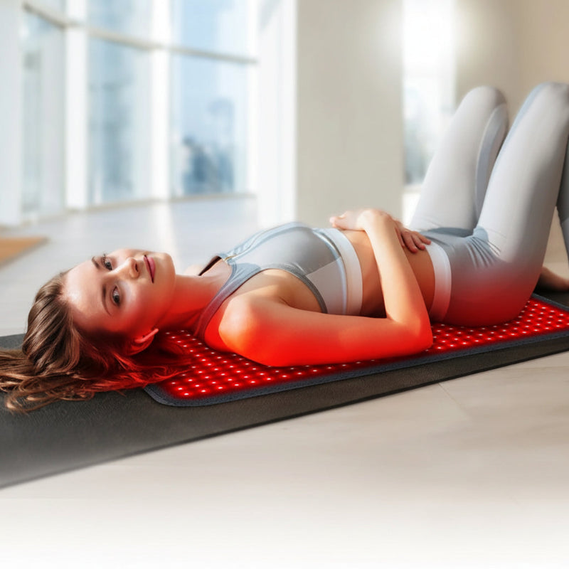 Woman lying on a red infrared mat 