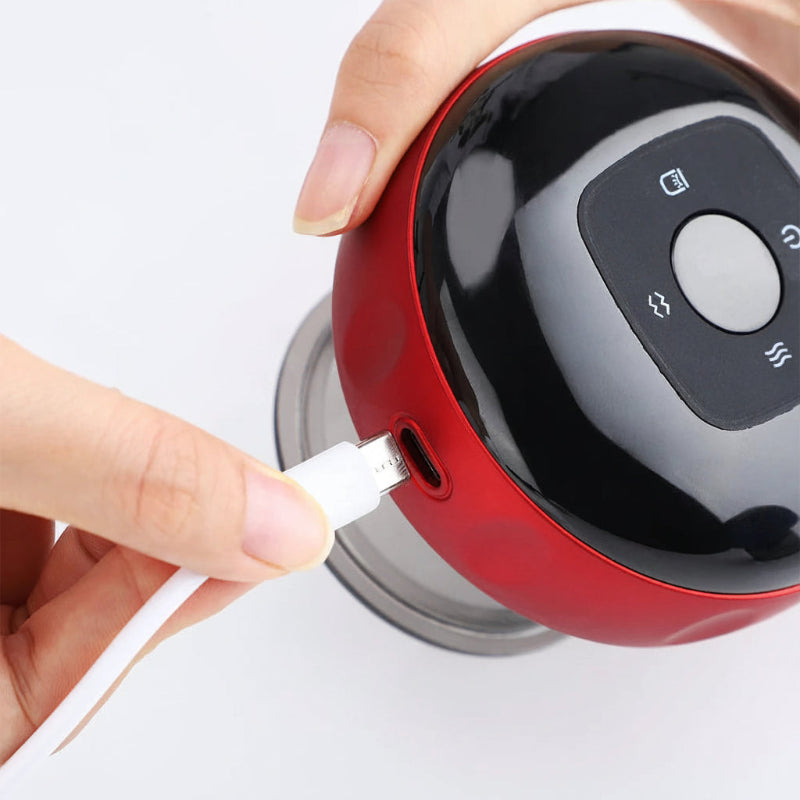 Red electronic device being charged with a USB cable, on a white background.