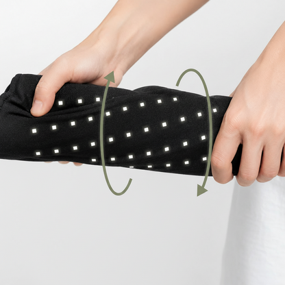 A person's hands stretching a red light therapy pad black arm sleeve with small white square lights, with green arrows 
